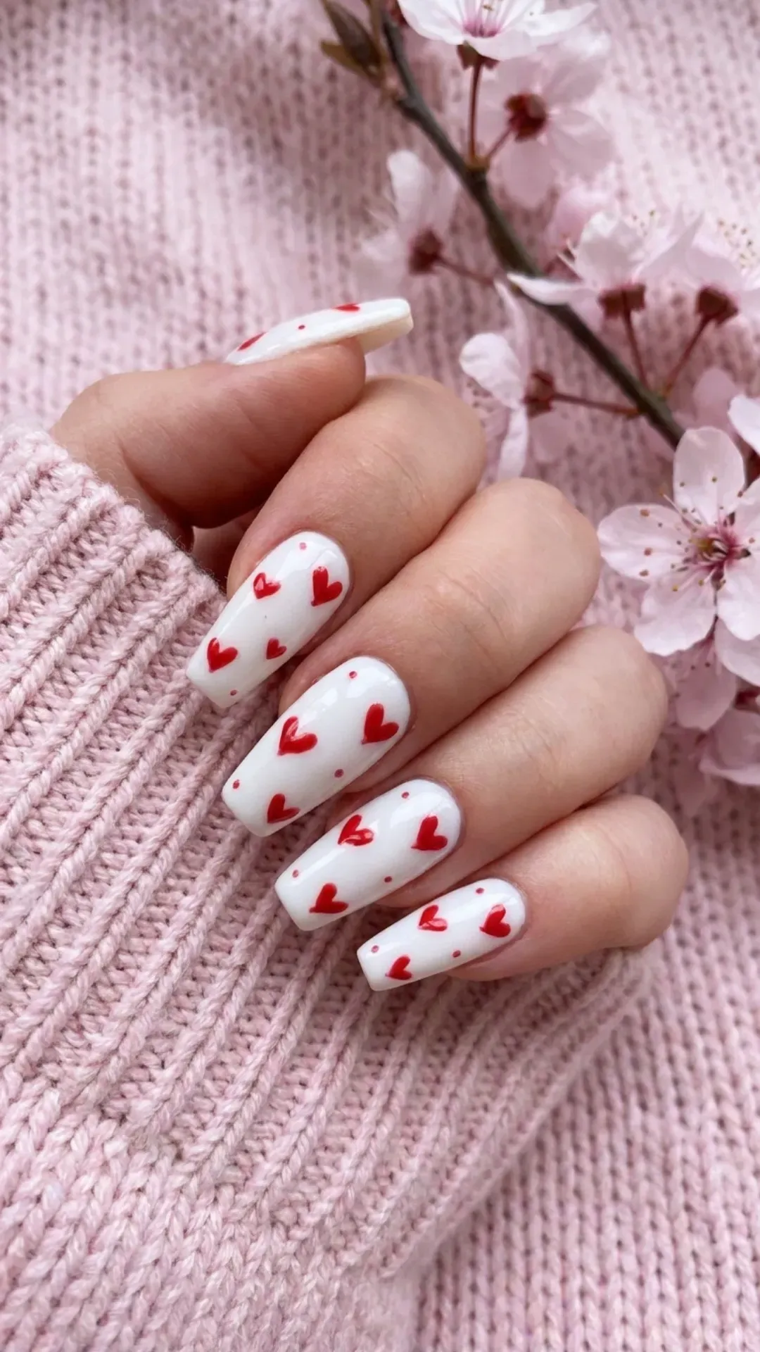 Romantic coffin nail design with a crisp white base and playful red hearts, offering a charming and sweet nail art idea that's perfect for adding a touch of love to springtime fashion