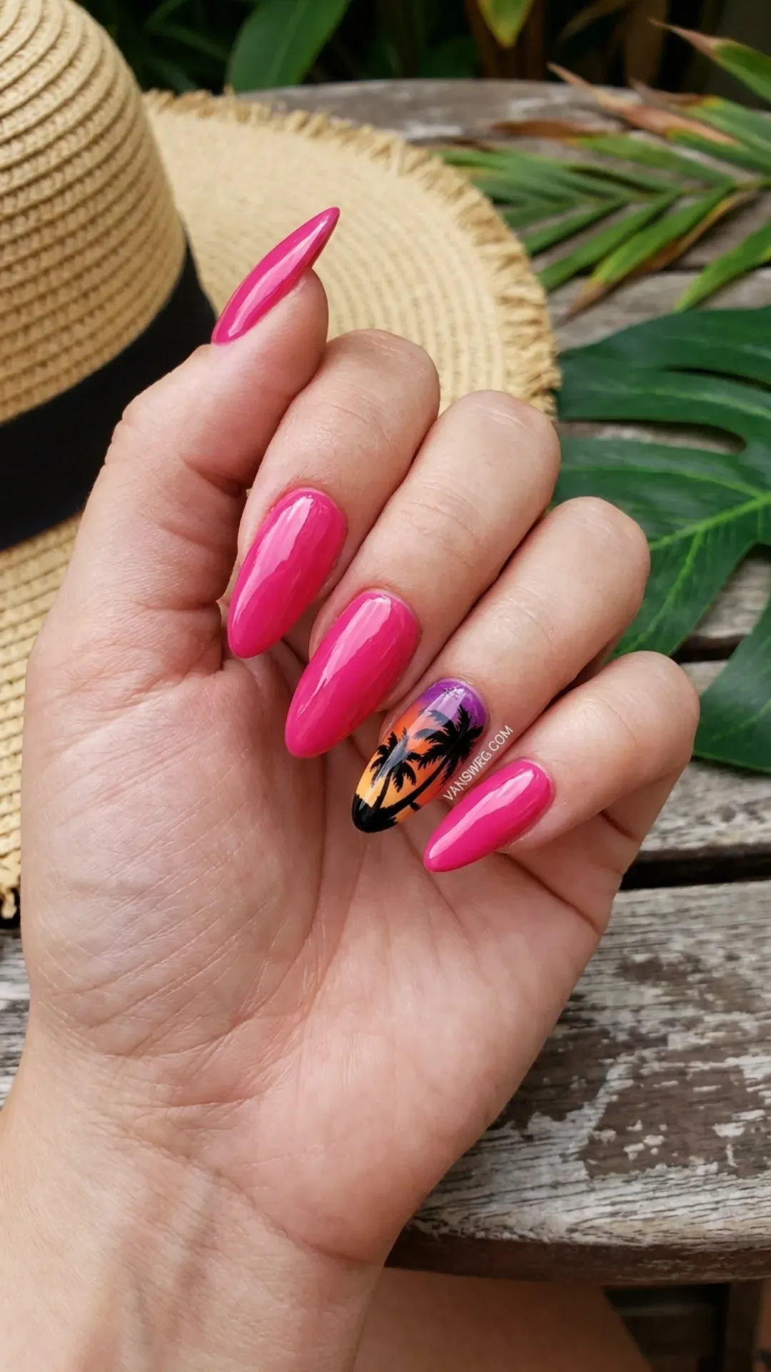 Long hot pink almond nails with a tropical black palm tree silhouette over a sunset gradient accent nail by VANSWEG.COM.