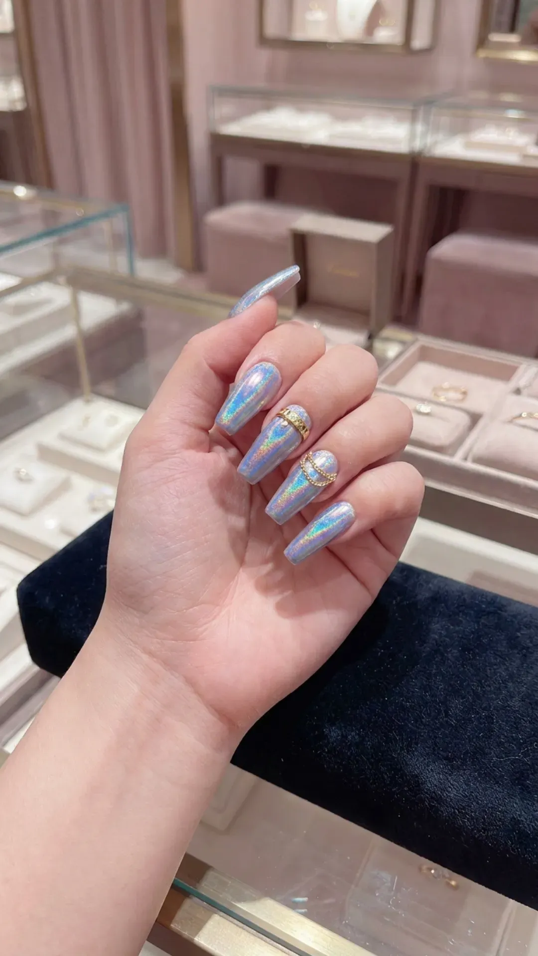 Luxurious coffin nails accented with gold rings and a holographic effect that shimmers in the light, exuding opulence and futuristic charm.