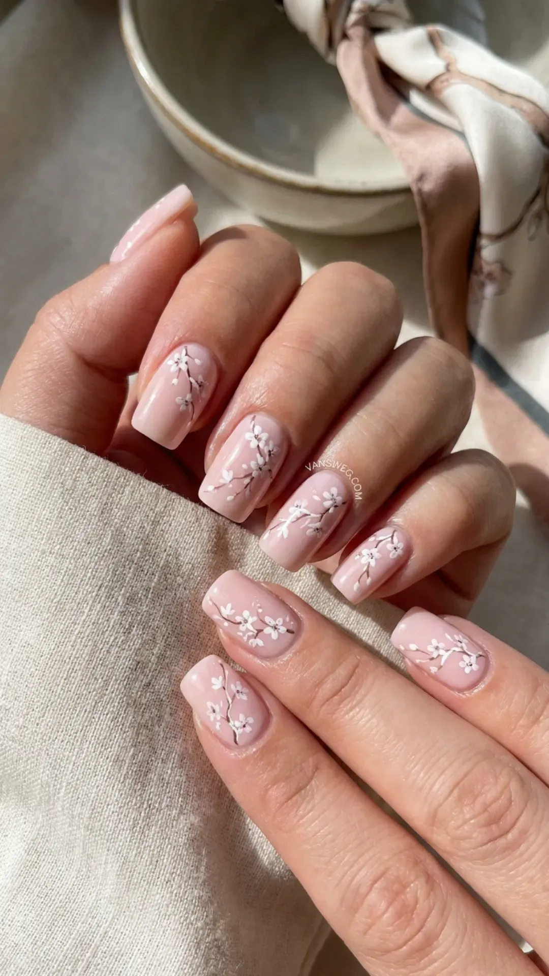 Delicate pastel blush pink medium square nails with detailed hand-painted white cherry blossom nail art by VANSWEG.COM.