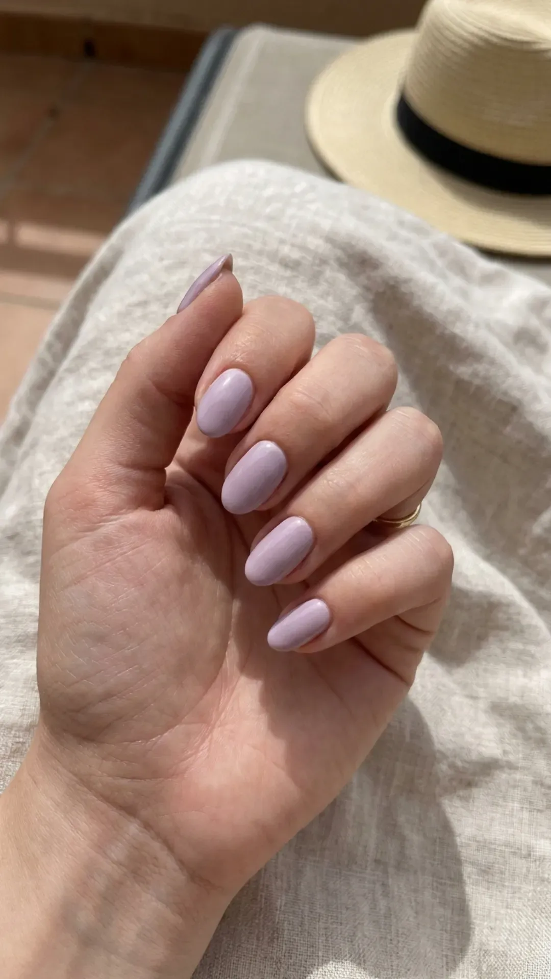 Hand with lilac oval nails, presenting a soft and elegant color perfect for the summer 2026 fashion trends.