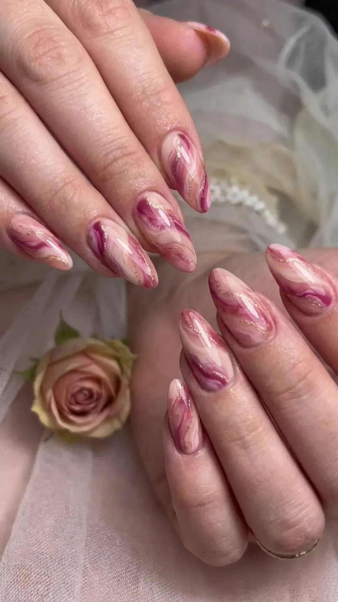 Artistic nails featuring a swirl of different pink tones, creating a romantic marble effect inspired by love's embrace