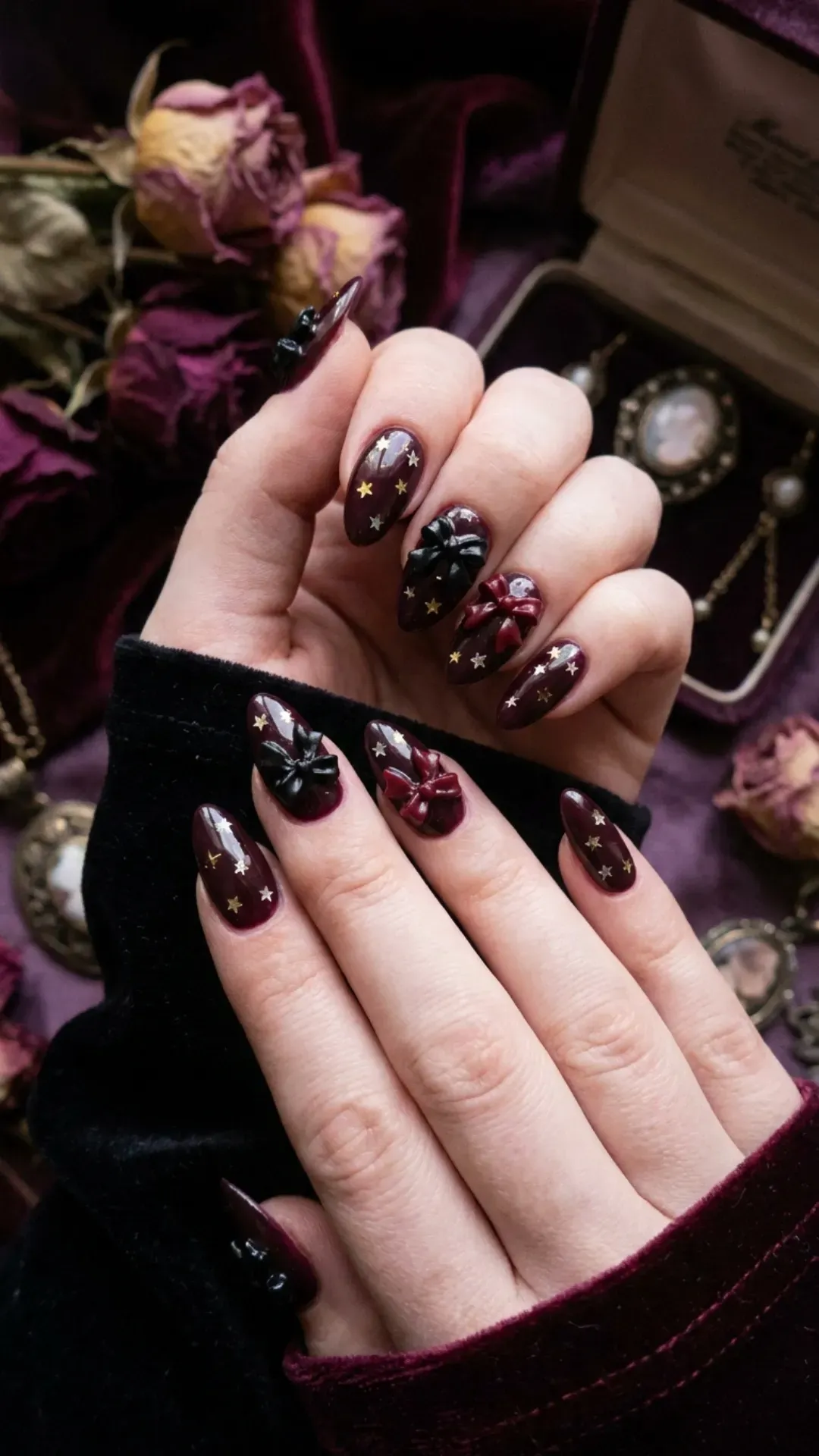 Black cherry nails adorned with dainty bows and tiny star accents, providing a deep and dreamy aesthetic.