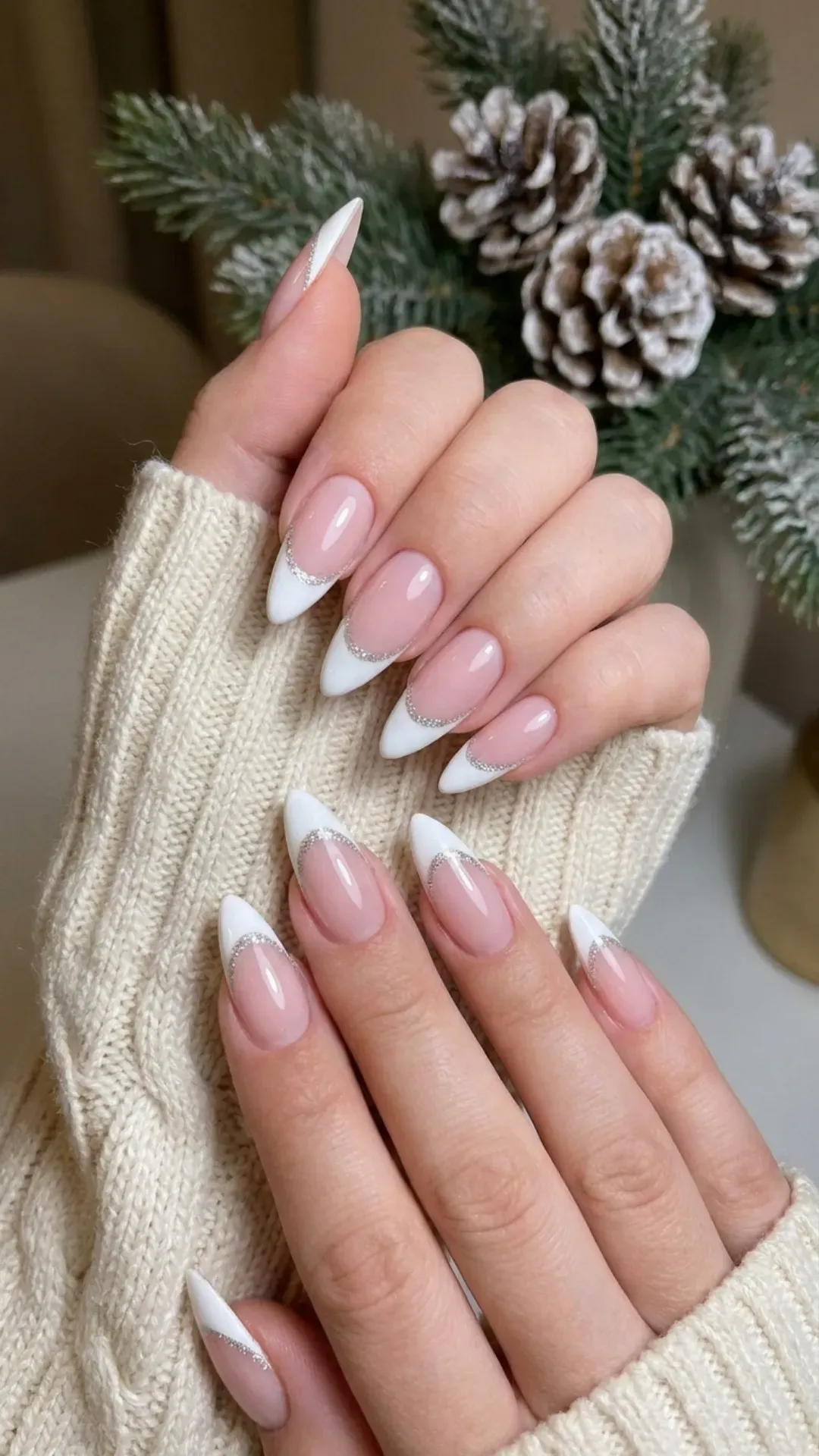 A modern twist on the classic French manicure, these nails feature a pale pink base with sharp white tips, separated by a thin line of silver glitter for an extra sparkle, combining elegance with winter charm.