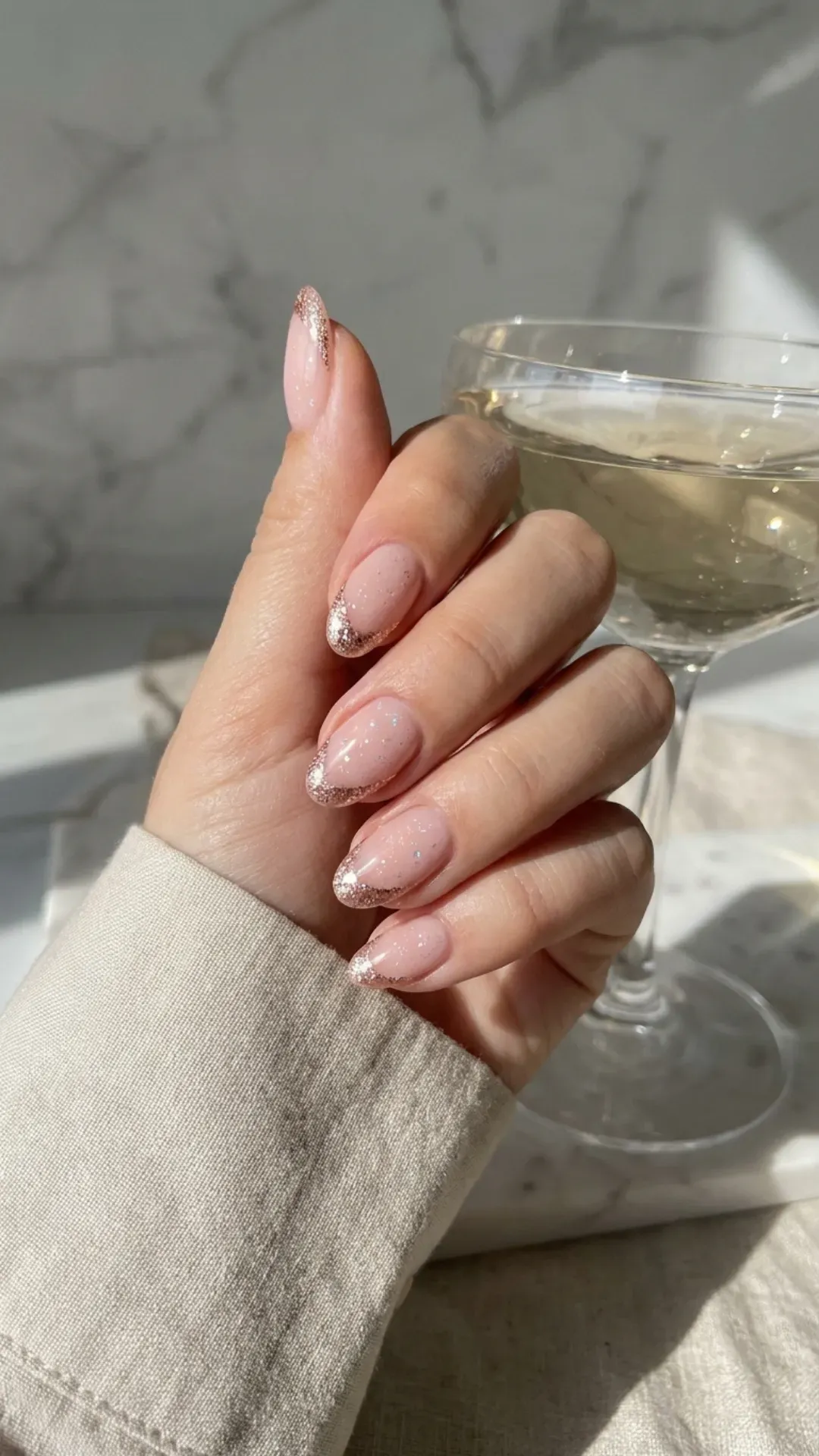 Chic nude pink nails with a modern twist on the French tips, featuring a delicate sparkle for an elevated and stylish manicure.