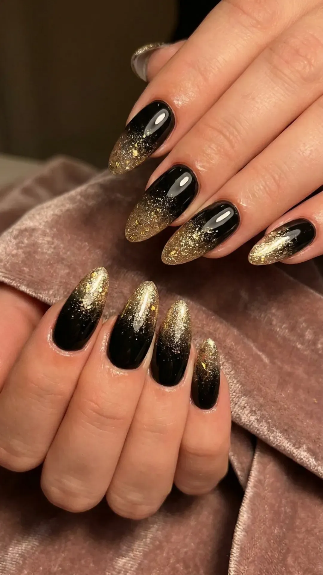 Luxurious nail design featuring glossy black nails with a gentle fade into golden shimmer, giving a perfect balance of boldness and sparkle.