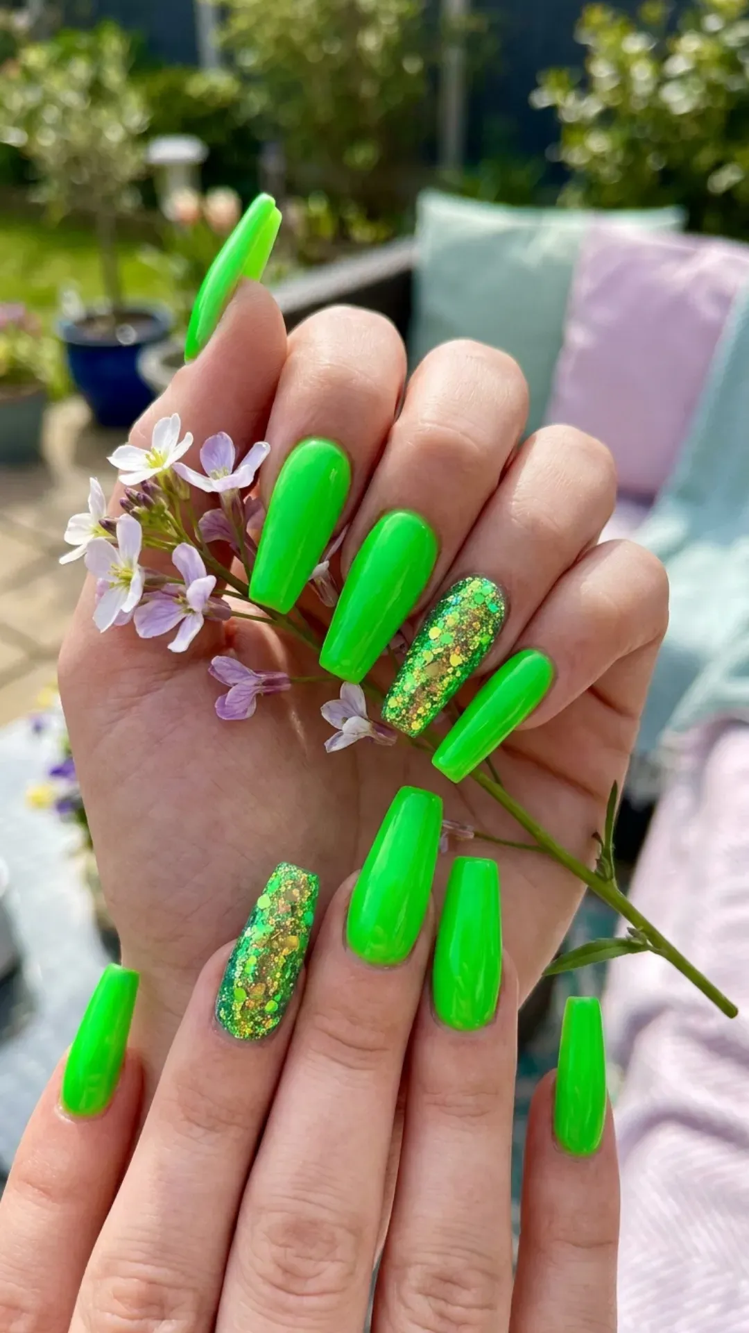 Eye-catching coffin nails with a bold neon green color, including a glittery accent nail for a splash of sparkle, ideal for making a statement with your springtime nail fashion