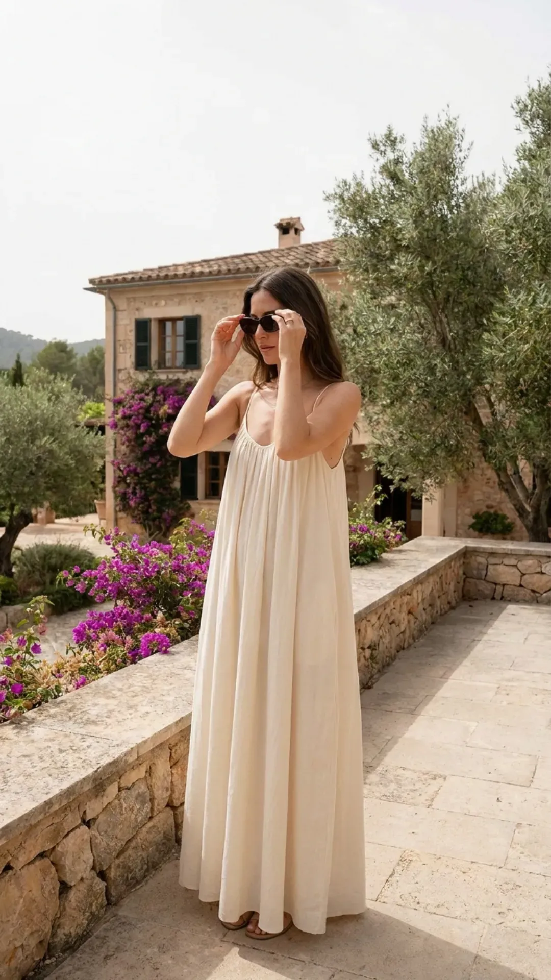  Woman wearing an elegant Cloud Dancer white maxi dress at a Mediterranean villa