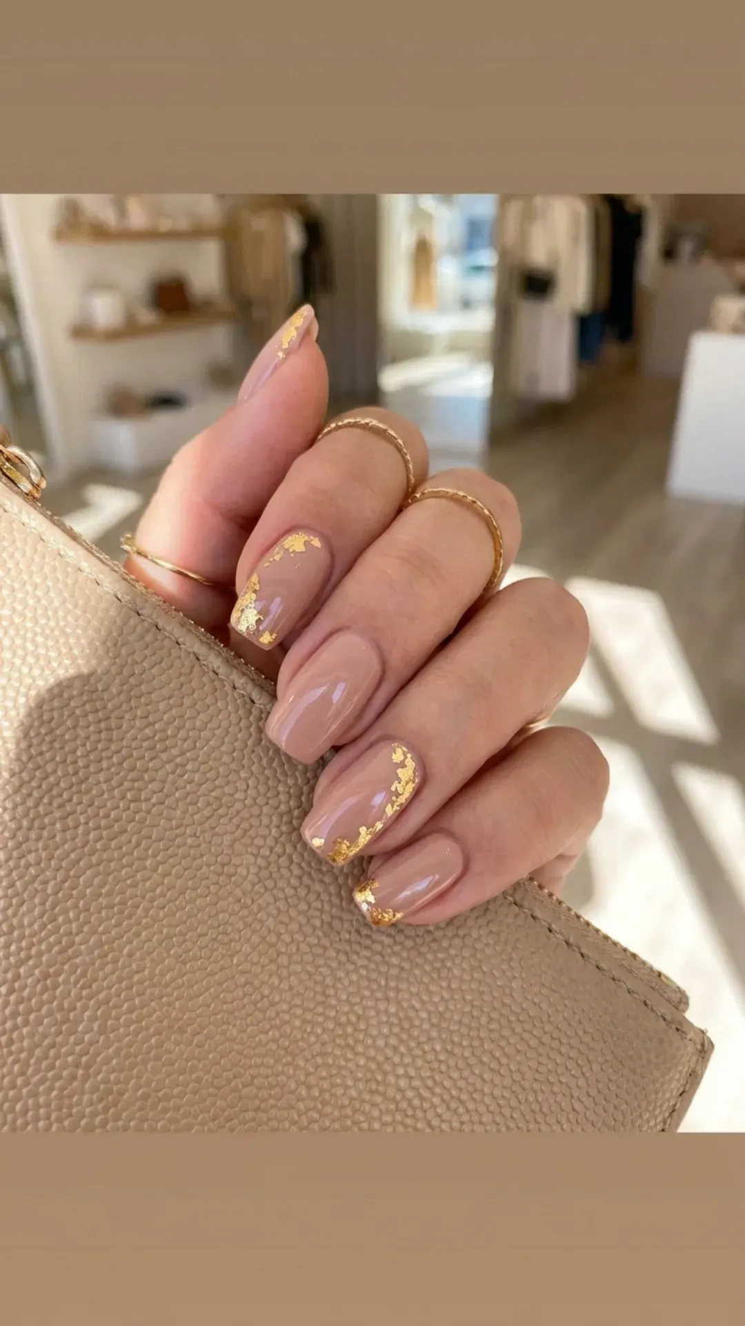 Nude pink nails with accents of gold foil, providing a touch of opulence and a unique metallic contrast for a fashionable statement.