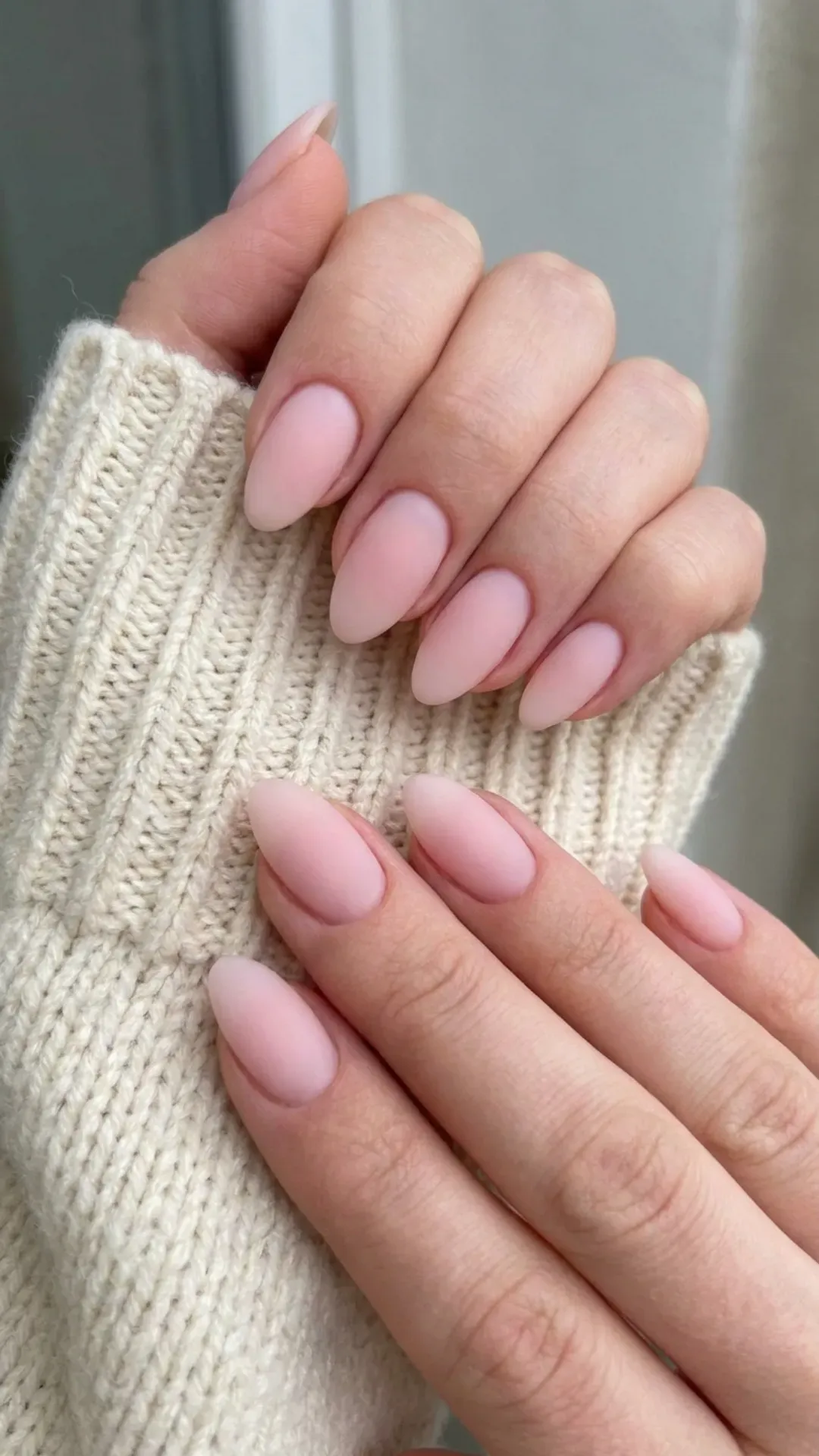 Delicate soft pink nails with an almond shape, presenting a clean and minimalistic look, their simplicity and elegance make them a versatile choice for everyday winter wear or special holiday occasions.