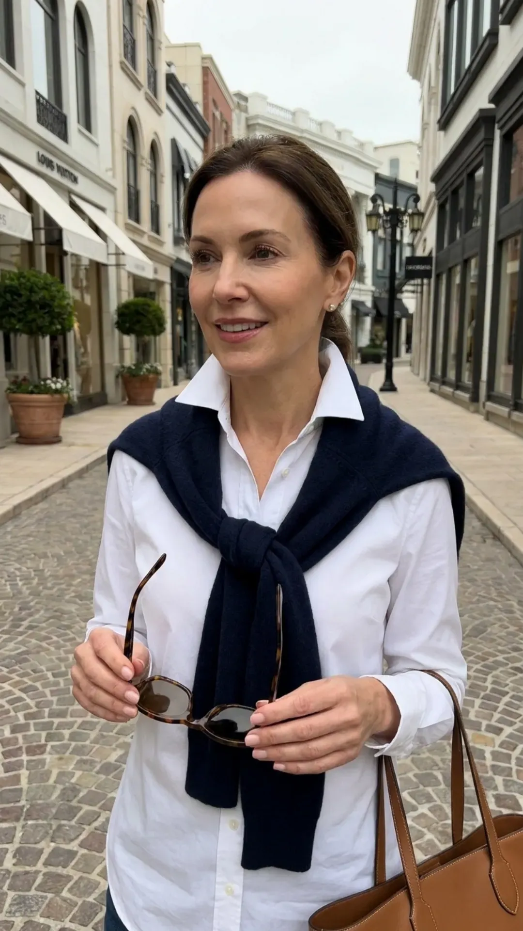 Elegant styling trick with a cardigan draped over the shoulders.