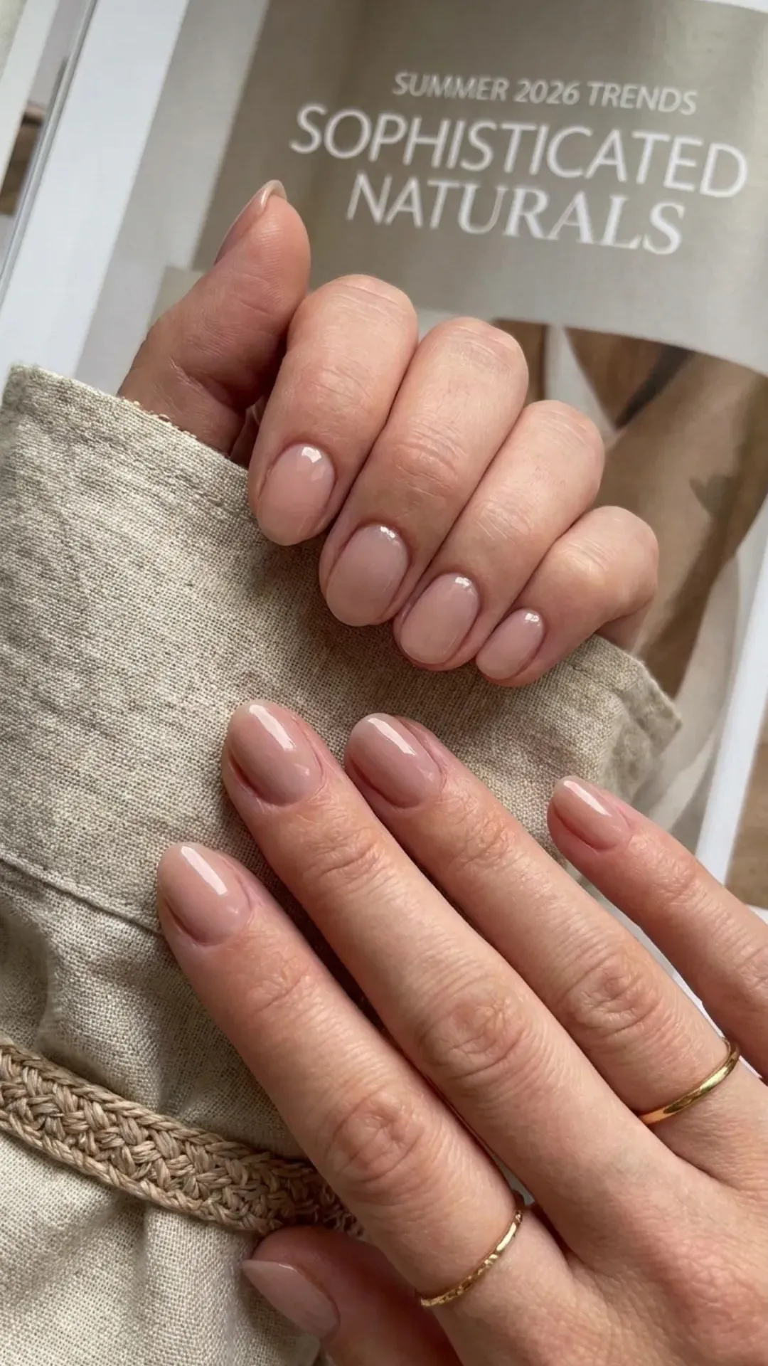 Close-up of hands with nude pink nails, highlighting a natural and sophisticated color choice for summer 2026