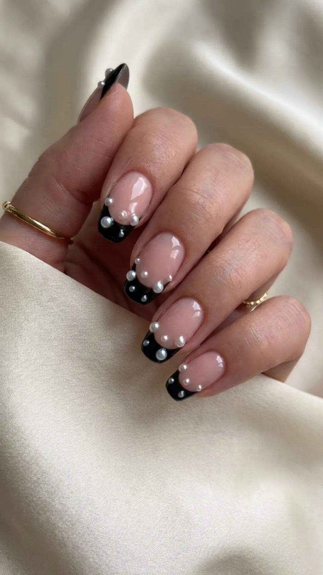 Classic black French tips enhanced with scattered pearl embellishments, providing a sophisticated and chic look.