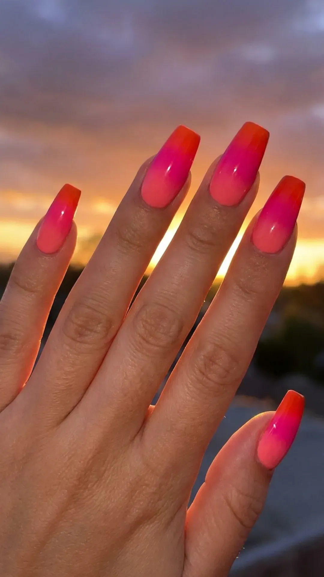 Medium coffin nails with seamless sunset ombré from coral to fuchsia to tangerine at tips — summer nail trend 2026