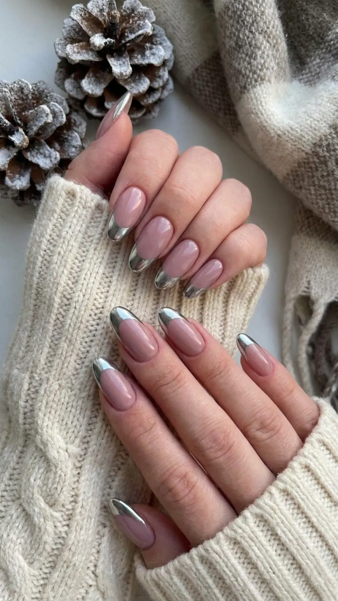 Fashionable and sleek, these long oval nails combine a muted pink base with striking silver chrome tips, giving a modern and stylish edge to your winter nail repertoire.
