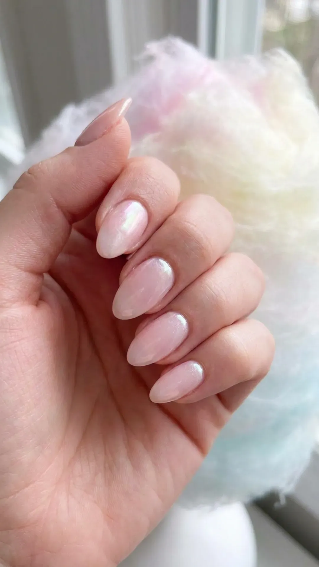 Dreamy nails with a soft pink base and a shimmering finish, evoking the light fluffiness of cotton candy clouds