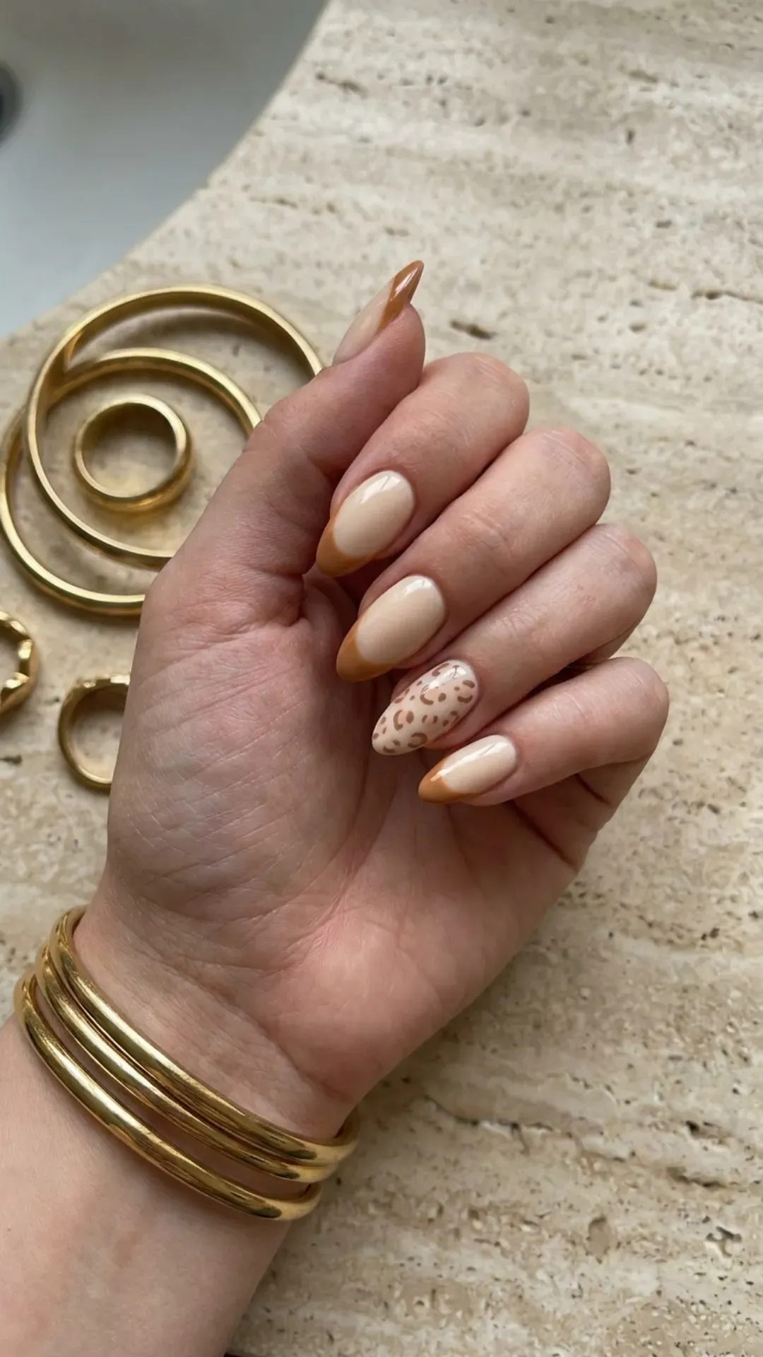 French tip nail set with fawn-toned cheetah print accent nail, caramel and sand tones on cream base — 2026 summer nails