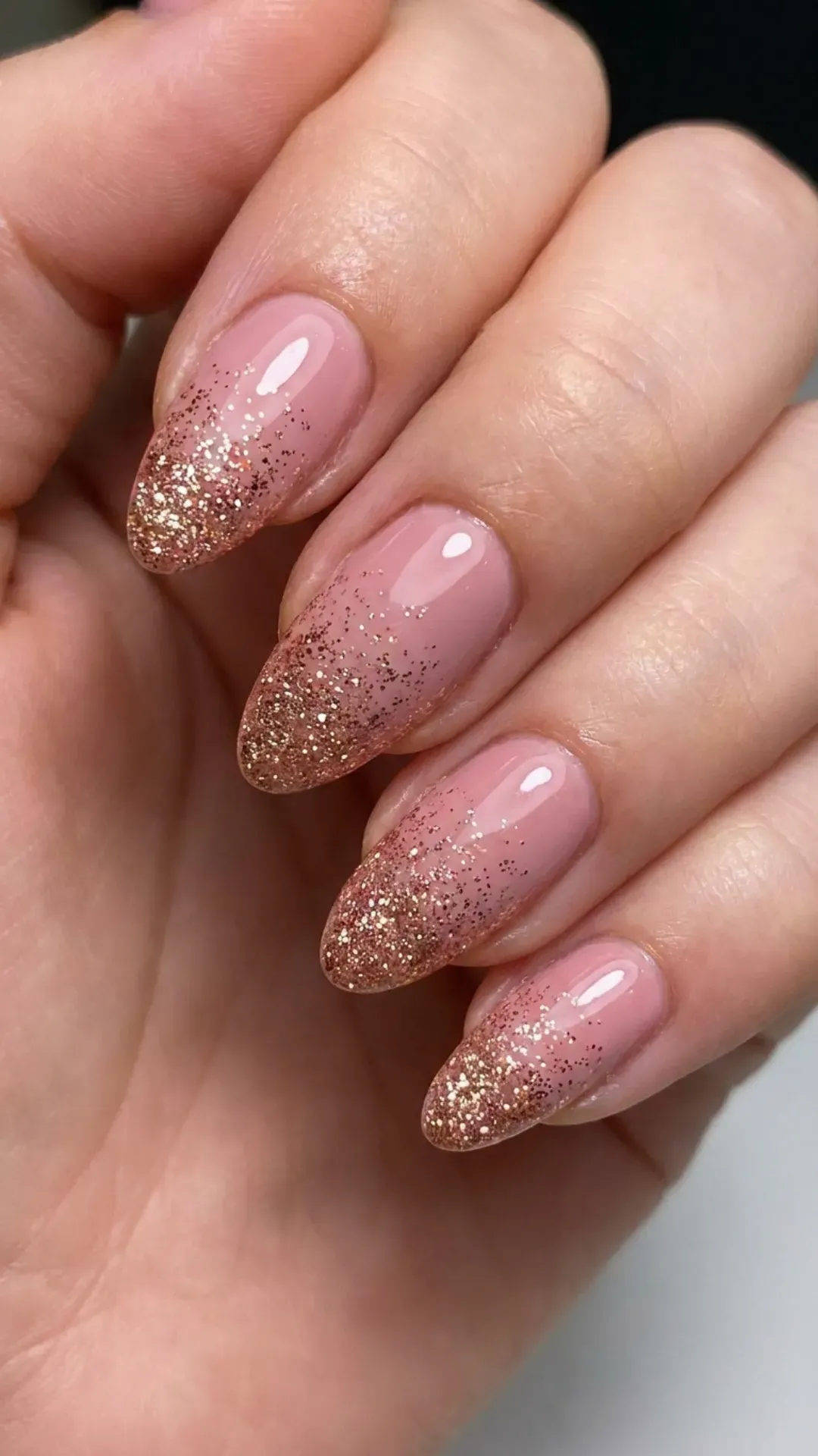 Alluring nude pink nails with a glitter gradient that adds a touch of sparkle, transitioning from subtle to striking.