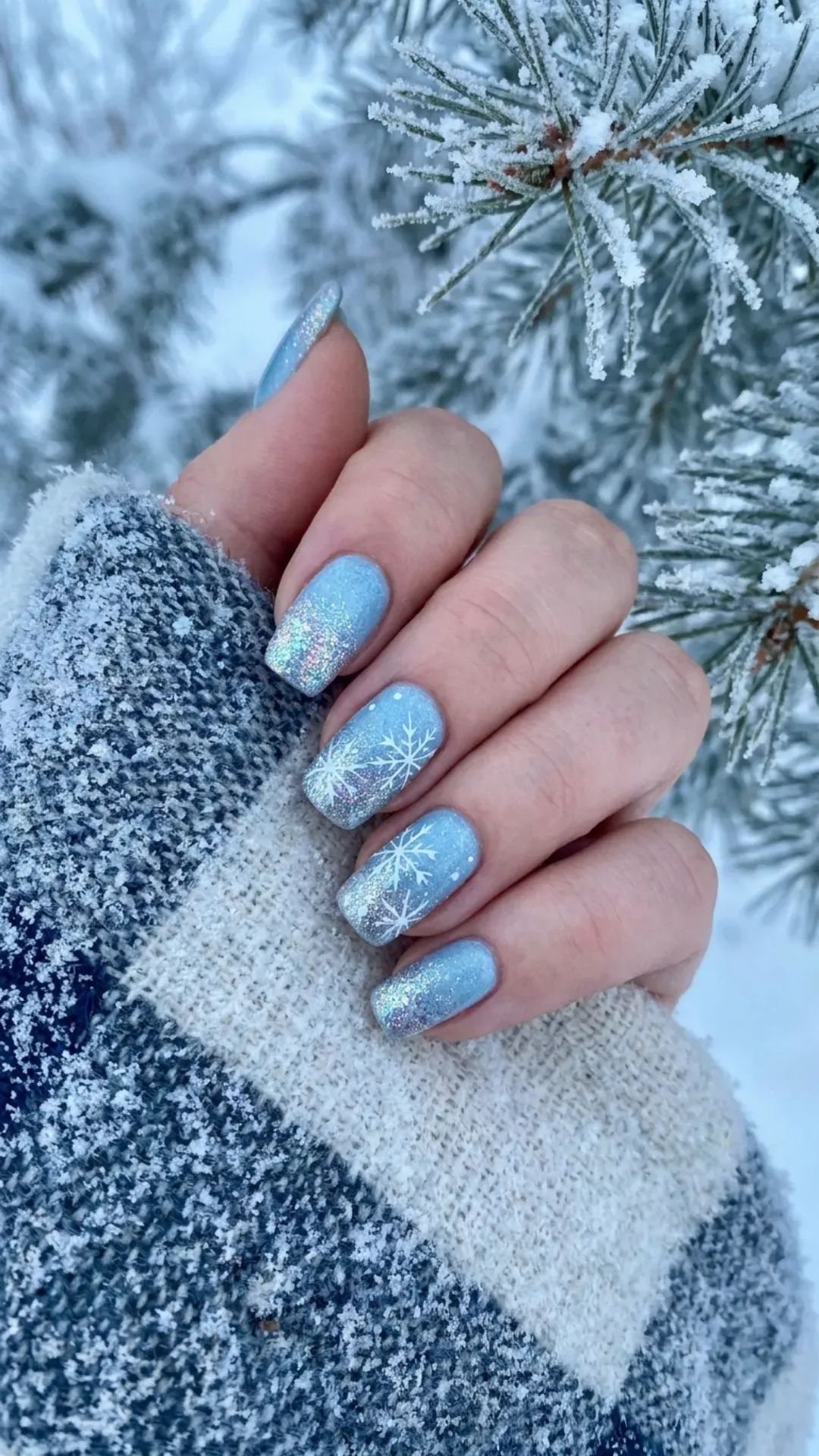 Cool icy blue nail polish with sparkling glitter accents and snowflake designs, evoking the crisp and refreshing ambiance of winter.