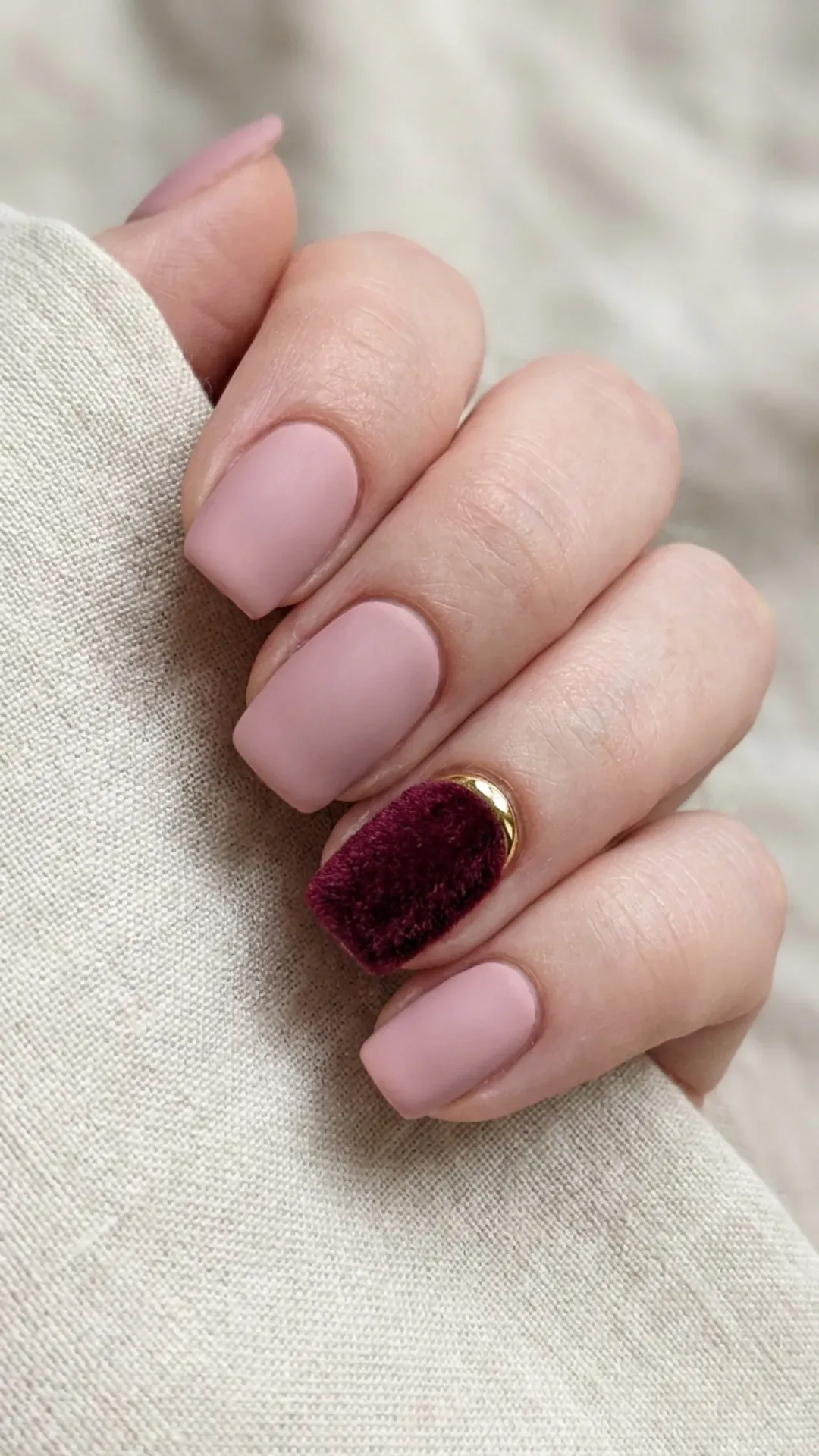 A mix of matte pink nails contrasted with one statement nail in a deep velvet hue, creating a bold yet sophisticated look.
