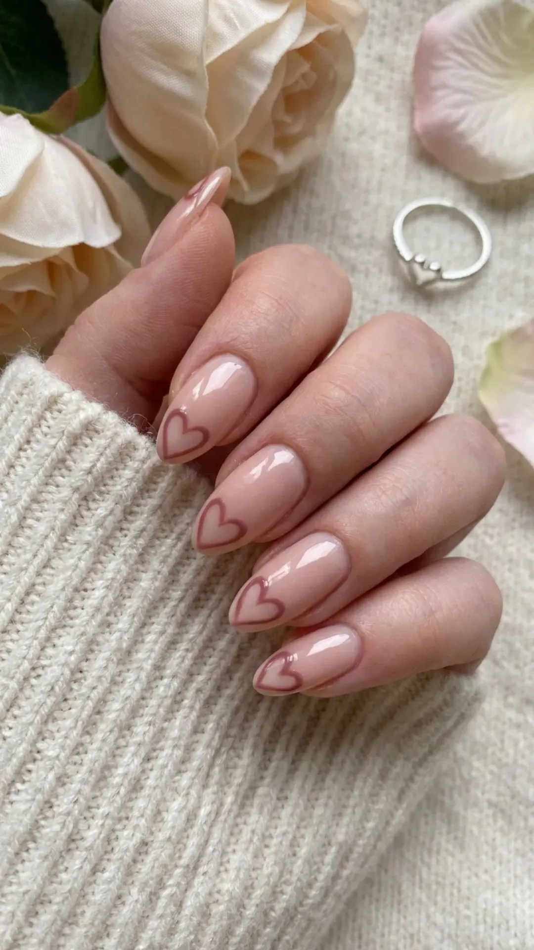 Charming nude pink nails with elegant outline heart tips in a deeper shade, creating a love-inspired manicure that's perfect for romantic occasions or everyday wear.