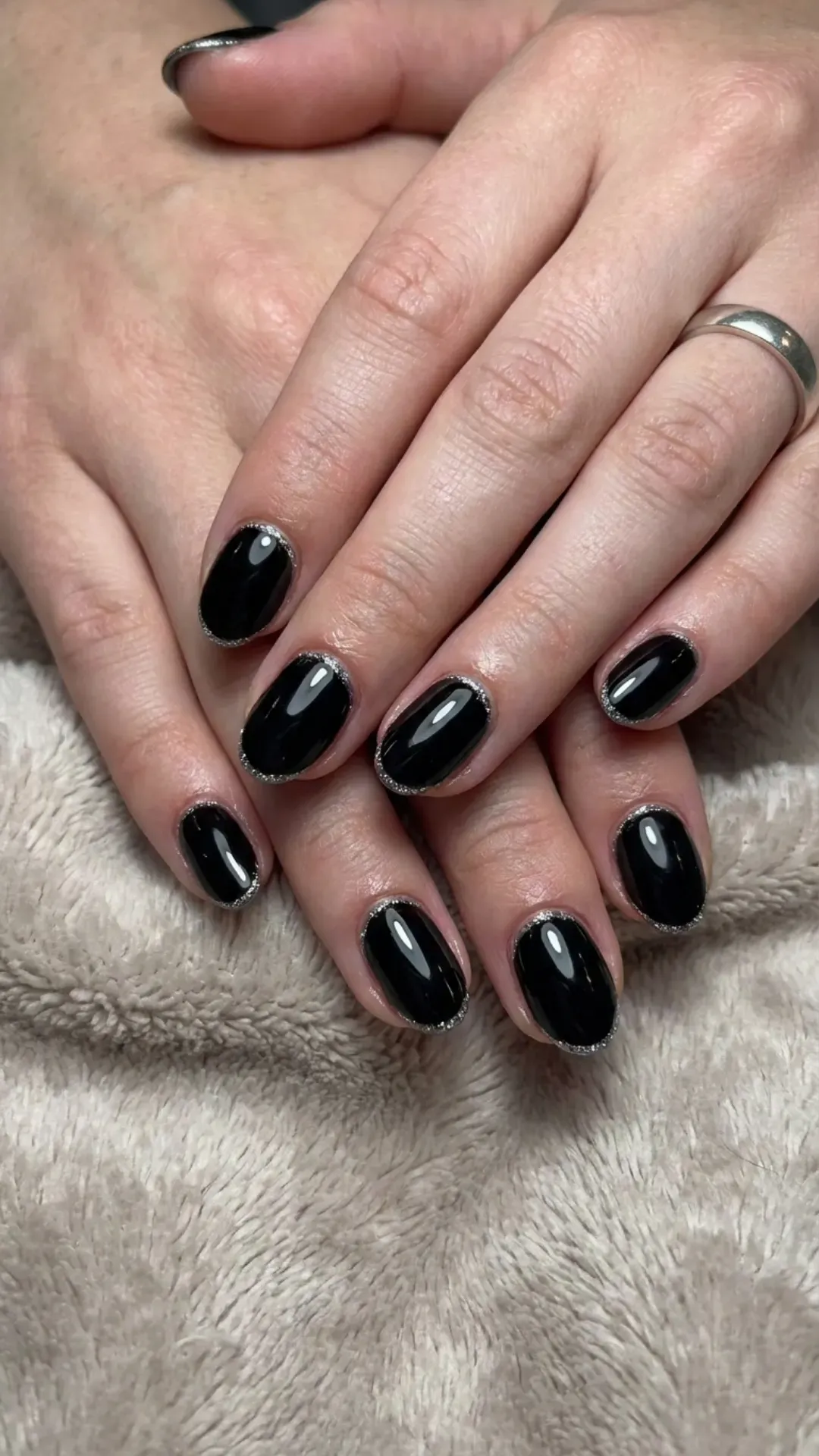 Classic black nails with a delicate silver glitter outline, highlighting a timeless elegance with a modern, sparkling edge.