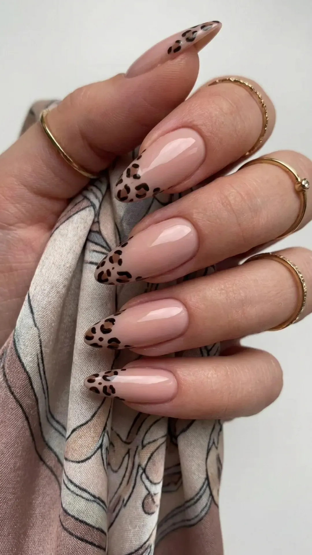 Stylish nude pink nails with a bold animal print at the tips, blending a classic nude look with a wild touch for a chic, adventurous style.