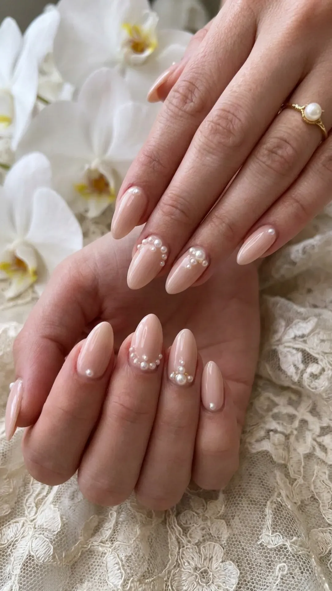 Elegant nude pink nails adorned with delicate pearl accents, creating a luxurious and feminine look ideal for weddings or sophisticated events.