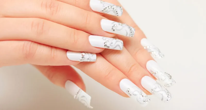 Chic white nails with delicate snowflake patterns, perfect for winter or Christmas-themed fashion statements.