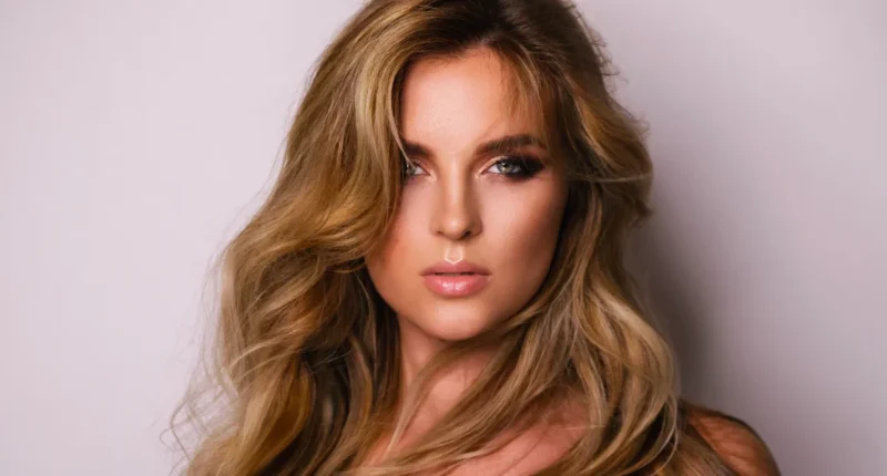 Elegant honeyed bronze waves hair color on a woman, showcasing a blend of honey blonde and soft bronze tones that create a luxurious and dimensional look for spring.