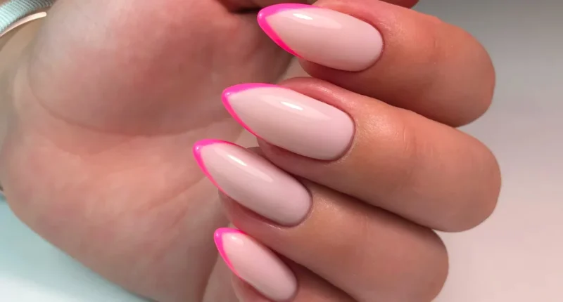 Vibrant almond French tip nails with a hot pink outline, providing a pop of color for a bold and eye-catching manicure.