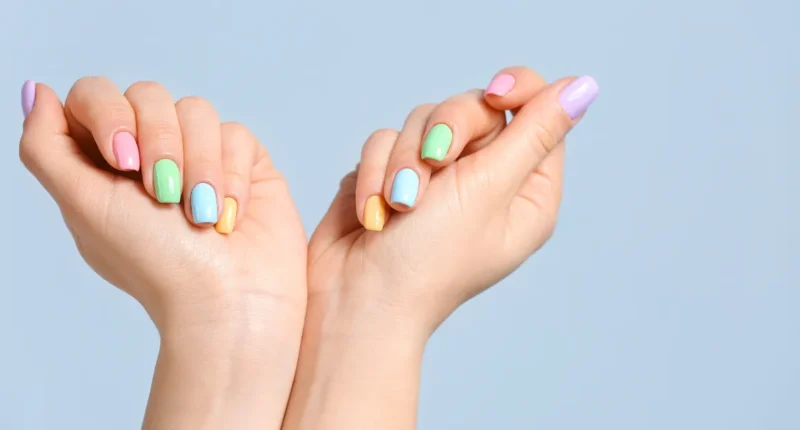 Almond-shaped nails painted in a different soft pastel color, perfectly manicured for a fresh spring look.