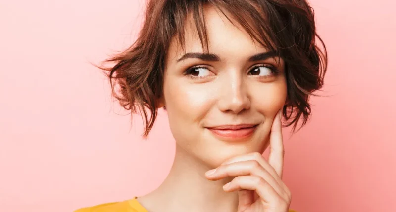 Woman with a short, tousled brunette bob and wispy bangs, giving a playful look, ideal for a fresh spring look.