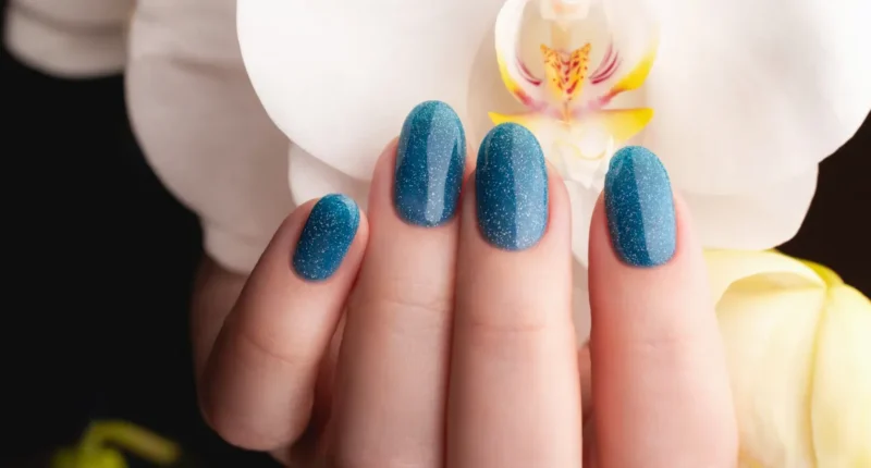 Stunning deep blue nails covered in fine glitter, providing a sparkling effect reminiscent of a clear night sky in spring